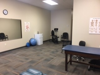 Open treatment area with a treatment table, exercise balls and equipment